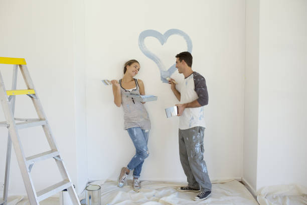 istock Couple painting blue heart on wall 184314546