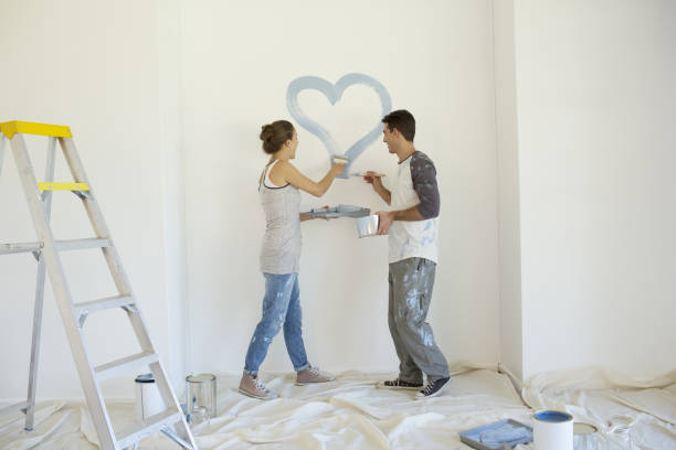 istock Couple painting blue heart on wall 184314605