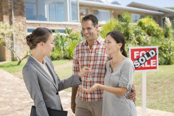 istock Real Estate Agent giving couple keys to new house 184314607