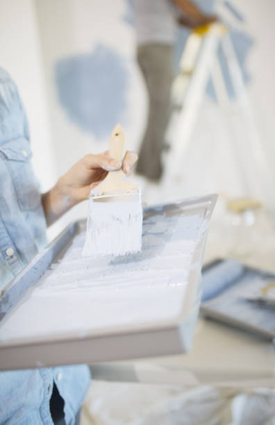 istock Woman holding paint tray with blue paint 184314654
