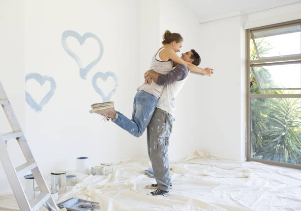 istock Couple painting blue hearts on wall 184314699