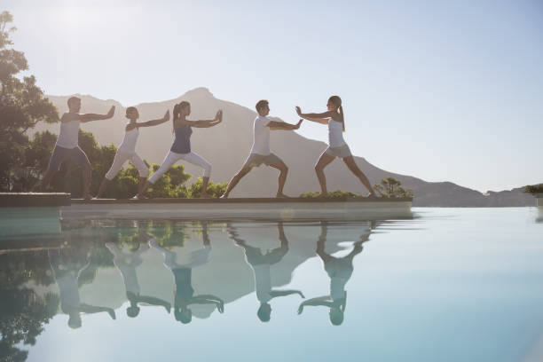 People practicing tai chi poolside  women exercising swimming pool young women stock pictures, royalty-free photos & images