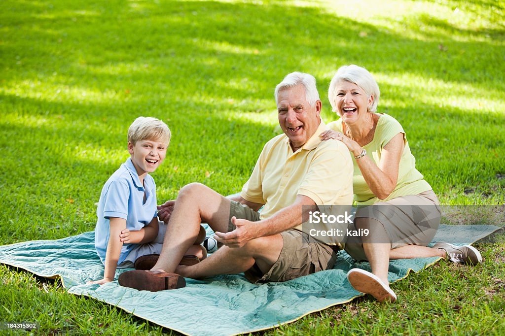 Бабушкой и дедушкой и Внук Смеяться вместе на открытом воздухе - Стоковые фото 60-69 лет роялти-фри
