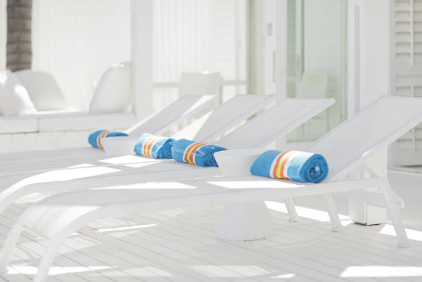 istock Striped towels rolled up on white lounge chairs 184315555