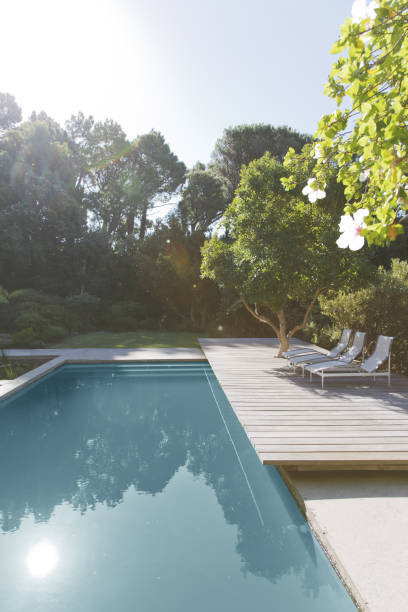 istock Wooden deck and lounge chairs by swimming pool 184315873