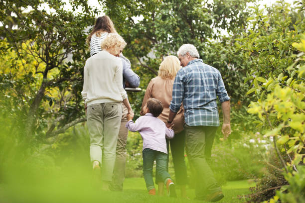 multi-generazione famiglia a piedi nel parco - grandparent foto e immagini stock