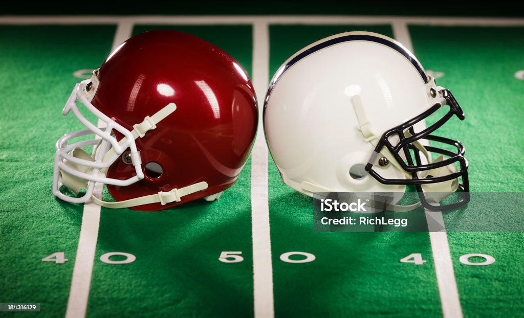 Two Football Helmets Two American football helmets on a football field. Football Helmet Stock Photo