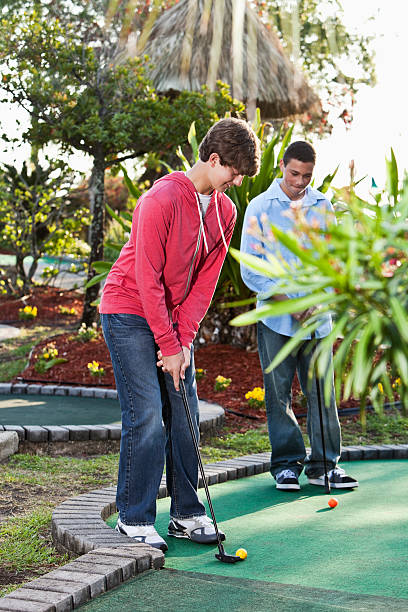 istock Teenage boys playing miniature golf 184317085