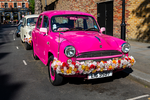 London, United Kingdom - June 1, 2023:  funny old pink car at a residential area in London.