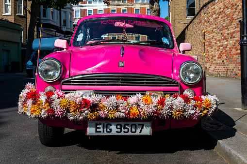 London, United Kingdom - June 1, 2023:  funny old pink car at a residential area in London.