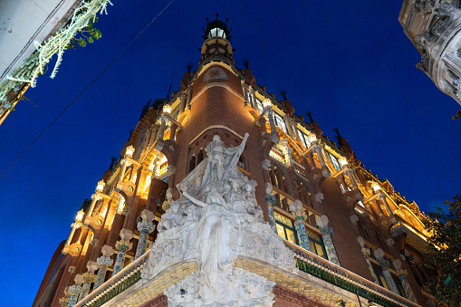 Barcelona, Spain. 12-09-2023.  Palau de la Música Catalana's corner sculptures illuminated against the night sky in Barcelona. The intricate details and artistic expressions of these sculptures add a touch of grace to the architectural masterpiece, making it a captivating sight after sunset