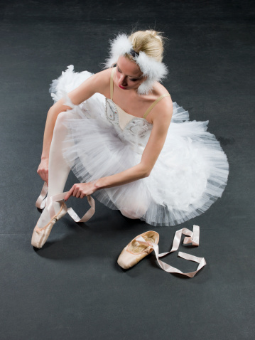 Ballet dancer getting her dance shoes for warm up before presentation