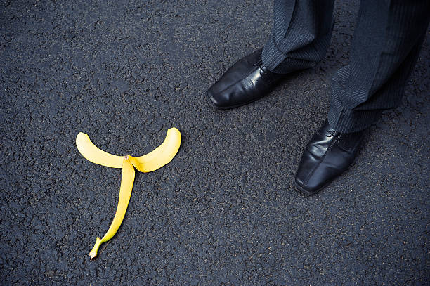 istock Businessman Stands next to Banana Peel on Black 184318501