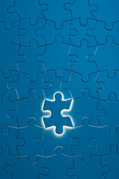 istock Blue jigsaw puzzle with one piece glowing 184318646