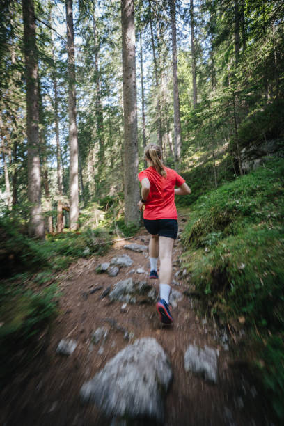 istock Female trail runner bounds along trail in forest 1843187431