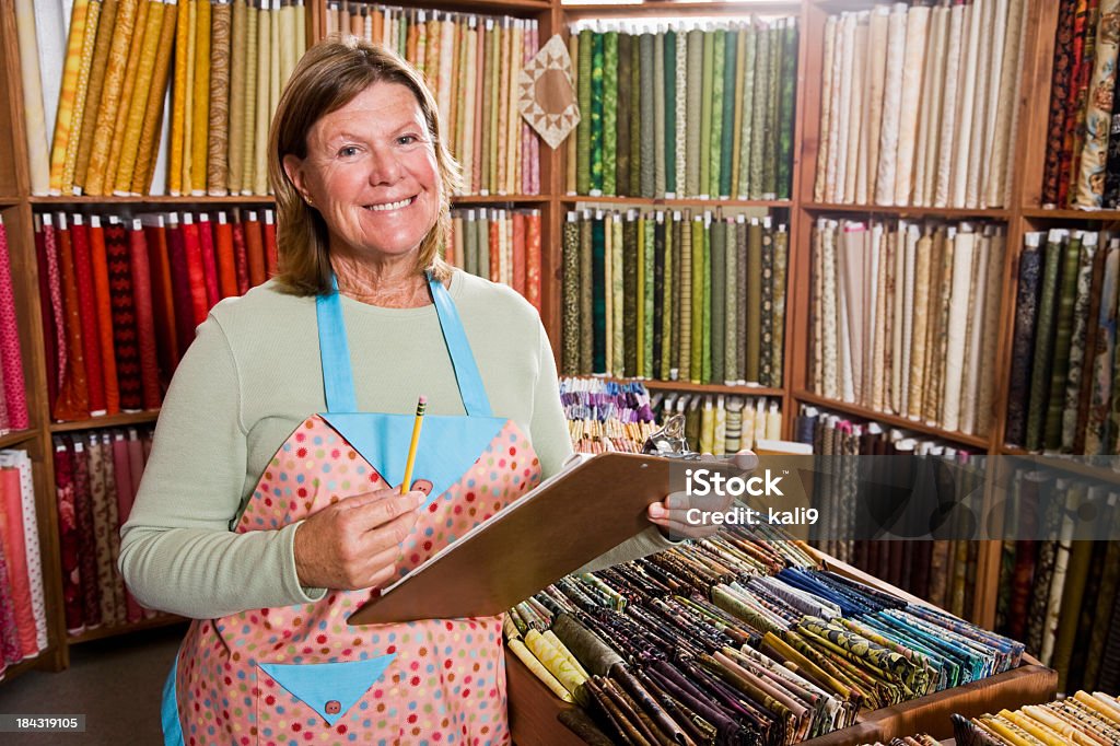 Mujer tomando inventario en tienda de telas - Foto de stock de 60-64 años libre de derechos