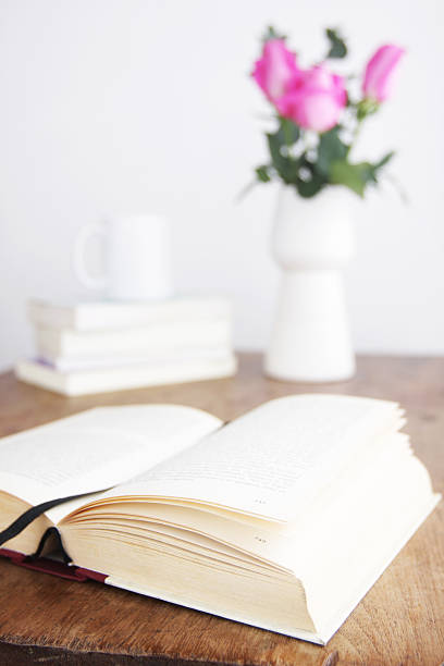 istock Open book on table with coffee and bouquet at background 184319154