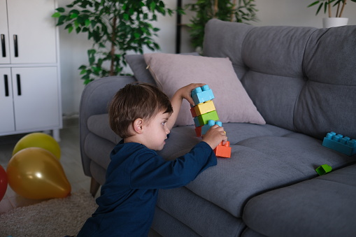 Little boy playing plastic blocks