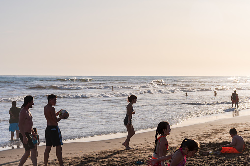Some bathers enjoy playing on the vast beaches of Necochea in the south of Buenos Aires Province, Argentina, on a summer afternoon.