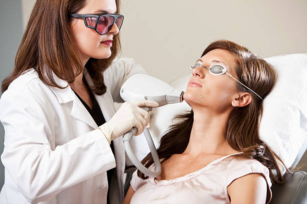 Laser hair removal Esthetician performing laser hair removal. aesthetician photos stock pictures, royalty-free photos & images