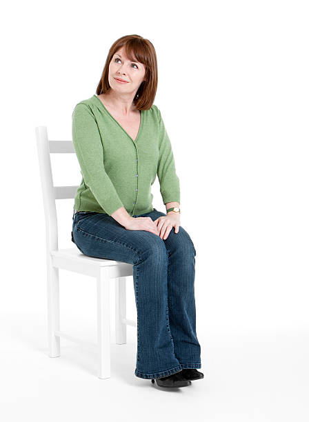 Portrait Of Mid Adult Man With Arms Crossed Sitting On Stool Against White Background