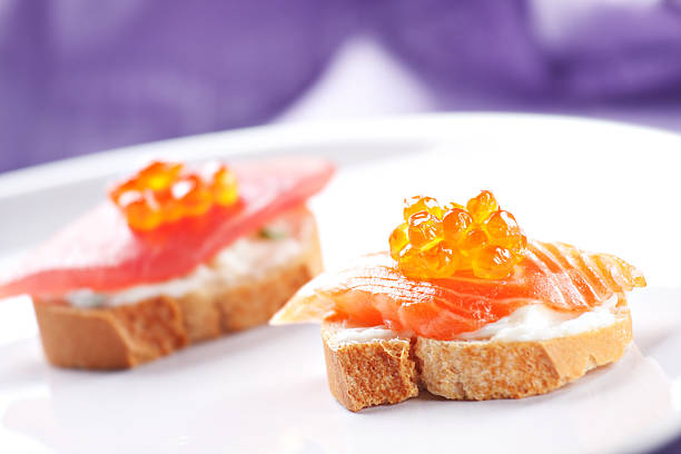 Delicious bread topped with fish, caviar, salmon and cucumbers.