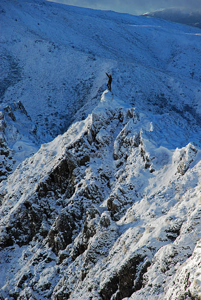 Mountain climber on snowy peak stock photo