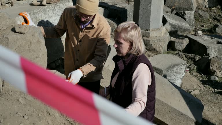 Archaeological excavation site: learned archaeologists discuss the details and details of the work on studying the destroyed temple of the medieval era. The excavation site is fenced off with tape