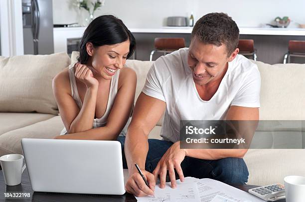 Couple Doing Paperwork With A Laptop Stock Photo - Download Image Now - Couple - Relationship, Form Filling, Tax Form