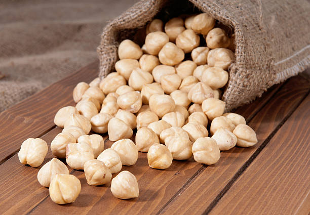 Bag of hazelnuts on wooden table stock photo