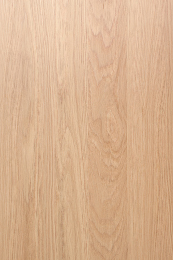 Rectangular cut out of hardwood on a white background.  A vertical cut of wood is placed in the center of the image and stretches from the top to the bottom surrounded by a white background on the left and right side of the image.  The wood is a lighter brown and beige color and shows texture with darker brown lines vertically running from the top to the bottom of the wood.  On the top middle of the wood piece, jagged lines in the shape of a V and W run through the center of the upper portion of the cut of hardwood.