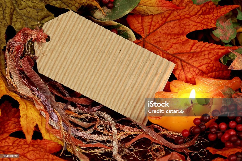 Blank Tag with Autumn Leaves and Candle Blank paper tag with ribbon, autumn leaves, berries and candle Autumn Stock Photo
