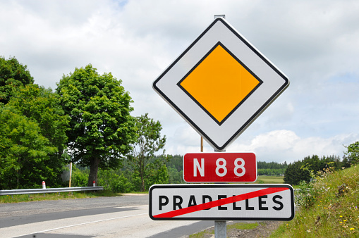 Roiad in France with signs indicating end of town boundary, priority road and national road number, N88