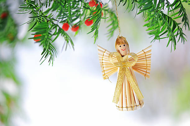 Christmas angel on christmas tree branch, lights hanging in a tree