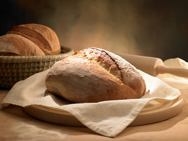 istock Rustic loaf of bread in cloth napkin and rolling pin 184323825