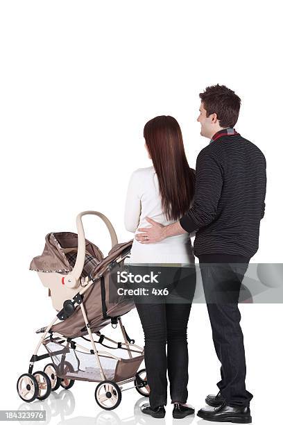 Couple Standing Near A Pram Stock Photo - Download Image Now - Cut Out, Young Family, Baby Stroller