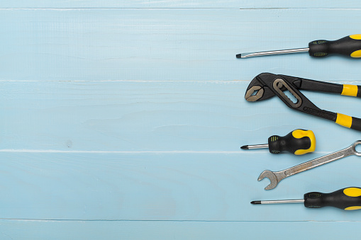 Set of tools on wooden background, top view