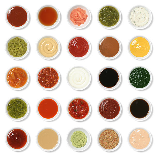 Isolated Condiment Collection Assortment "Twenty five everyday condiments isolated on white. From top to bottom, left to right, they are: barbecue sauce, malt vinegar, pickled ginger (gari shoga), tomatillo salsa (salsa verde), tartar sauce, chopped green chile, Dijon mustard, ketchup, satay sauce, yellow mustard, mango chutney, garlic chile sauce, mayonnaise, soy sauce, mint sauce, sweet pickle relish, hot wing sauce, salsa, sriracha, Worcestershire sauce, sweet and sour, tahini, wasabi, whole grain mustard, 1000 island." mustard fruits stock pictures, royalty-free photos & images