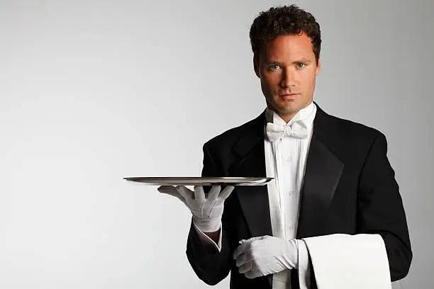 A butler or a waiter carrying an empty silver platter.