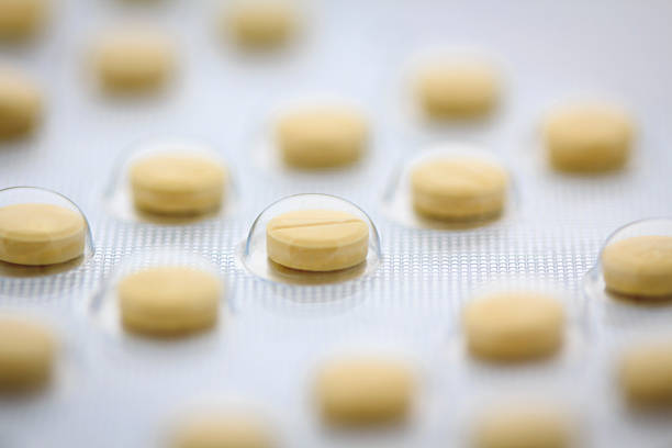 Effervescent tablet with vitamins on yellow background