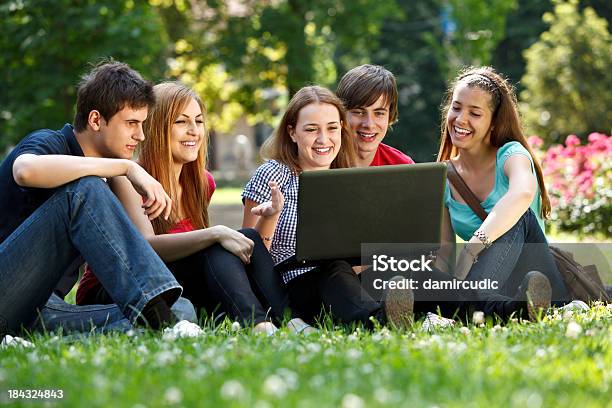 Photo libre de droit de Groupe Détudiants De Luniversité À Laide Dordinateur Portable En Plein Air banque d'images et plus d'images libres de droit de Adolescence