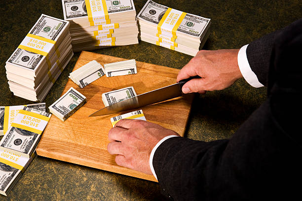 Budget Cutting - Congressman cutting stacks of money Budget Cutting - A politician trimming stacks of $100 bills with a Knife debt ceiling stock pictures, royalty-free photos & images