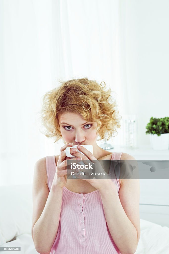 Morning caffee Pretty young adult woman wearing pink sleeveless top drinking coffee in the morning, looking at camera. 20-24 Years Stock Photo