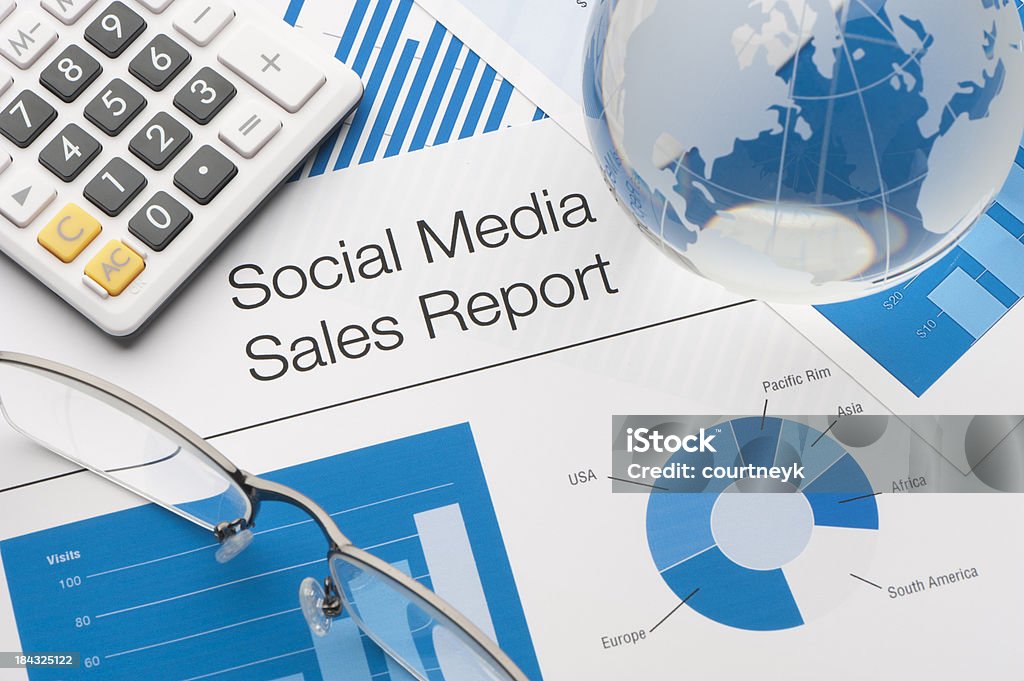 Close up of a social media sales report "Close up of a social media sales report with pen, calculator and globe" Business Stock Photo