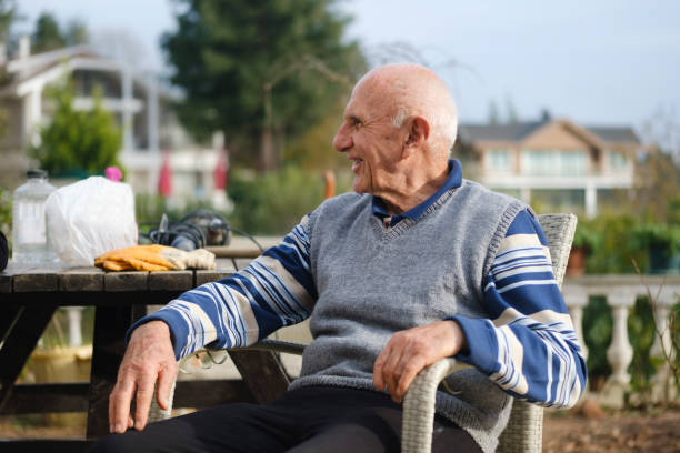 istock A happy old man sitting in his garden, looking sideways and laughing. 1843252870