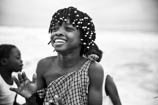 A happy African girl laughing at the beach.