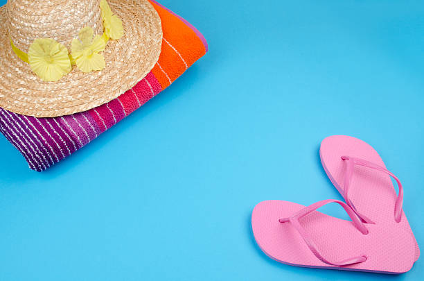 istock Flip-flops with sun hat and beach towel 184325429