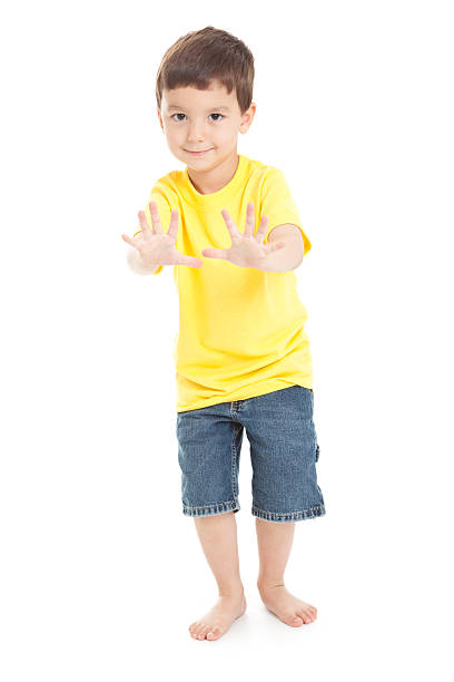 little boy with hands adelante sobre fondo blanco - isolated on white full length lifestyles yellow fotografías e imágenes de stock