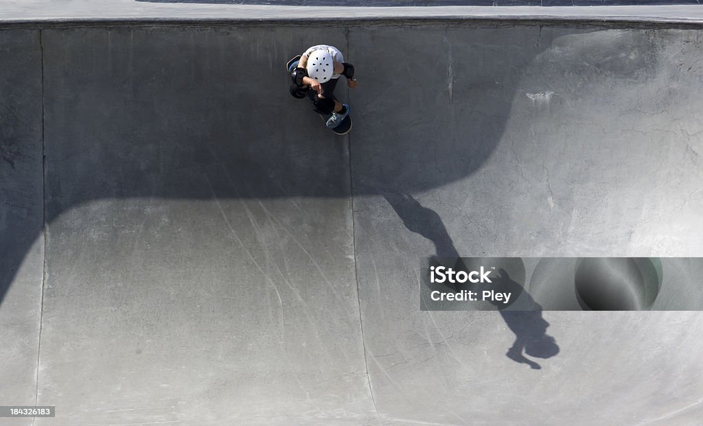 Skateboarder Young skateboarder at a skateboard park with shadow. Space for copy. Skateboard Stock Photo