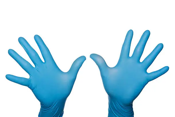 "Close-up of two blue surgical, medical gloved hands, palms facing viewer, fingers spread. Isolated on white. copy space above hands."